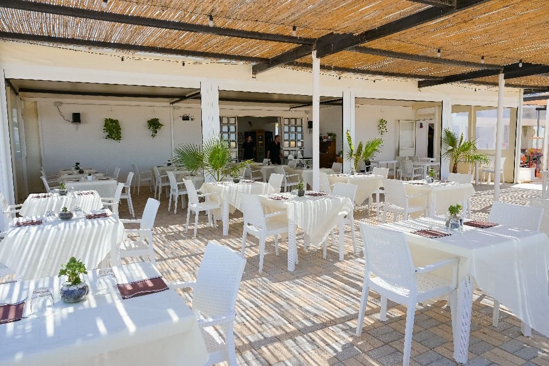 La terrazza coperta con i tavoli bianchi apparecchiati